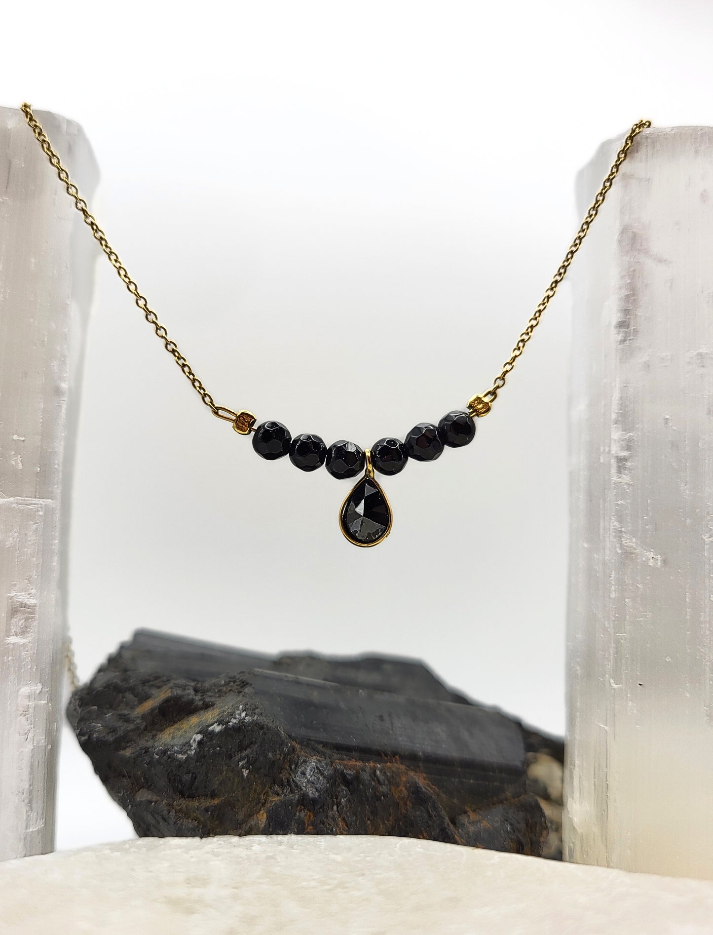 Nahaufnahme der Good Vibes Only Halskette mit schwarzem Turmalin auf Selenit-Kristallen, goldene Kette mit facettierten Edelsteinperle