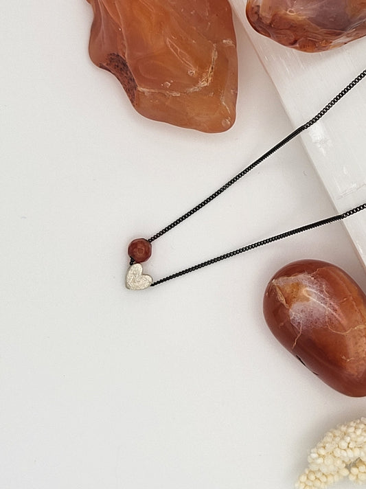 Handgemachte Halskette mit echtem Carneol und Herz aus 925er Silber an oxidierter Kette, minimalistischer Schmuck auf weißem Hintergrund.