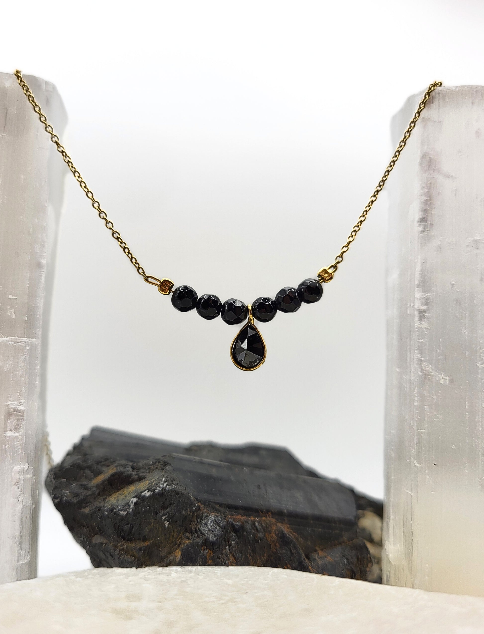 Nahaufnahme der Good Vibes Only Halskette mit schwarzem Turmalin auf Selenit-Kristallen, goldene Kette mit facettierten Edelsteinperle